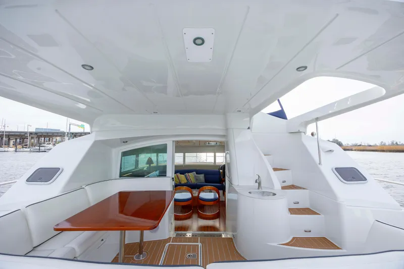  Yacht Photos Pics 2004 Lagoon 43 PC yacht interior with seating, table, and stairs, overlooking water.