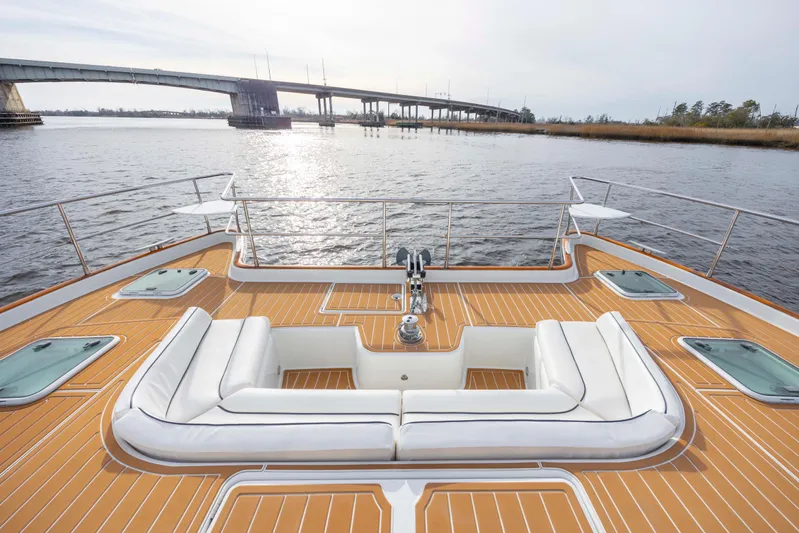  Yacht Photos Pics Luxurious 2004 Lagoon 43 PC yacht deck with white seating, overlooking serene waters and a bridge.