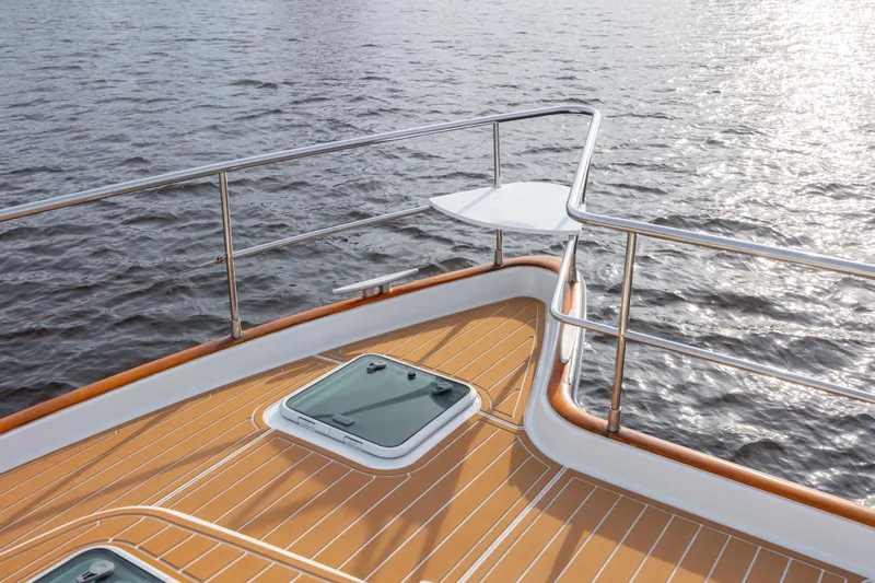  Yacht Photos Pics Deck view of 2004 Lagoon 43 PC yacht with wooden finish and ocean backdrop.