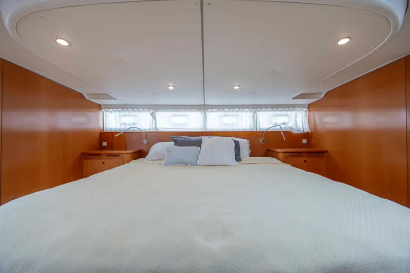  Yacht Photos Pics Luxurious bedroom interior of 2004 Lagoon 43 PC yacht with cozy bedding and wooden accents.