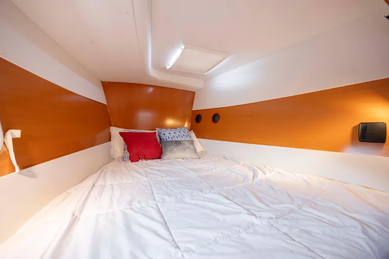  Yacht Photos Pics Cozy cabin interior of 2004 Lagoon 43 PC yacht with comfortable bedding and warm lighting.