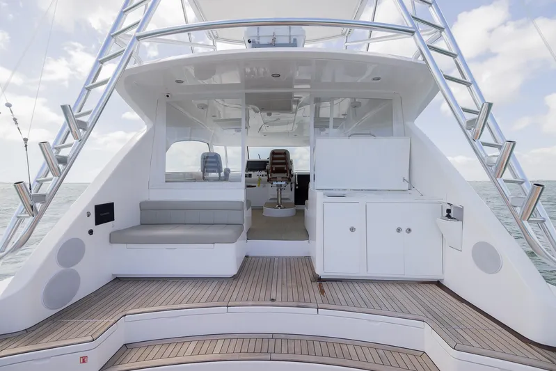  Yacht Photos Pics 2022 Bertram 50 yacht deck with seating and cabinetry, featuring sleek design and ocean backdrop.