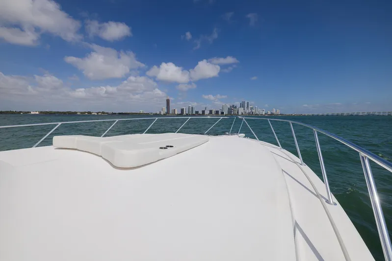 Yacht Photos Pics Bow view of 2022 Bertram 50 yacht approaching city skyline under blue sky.