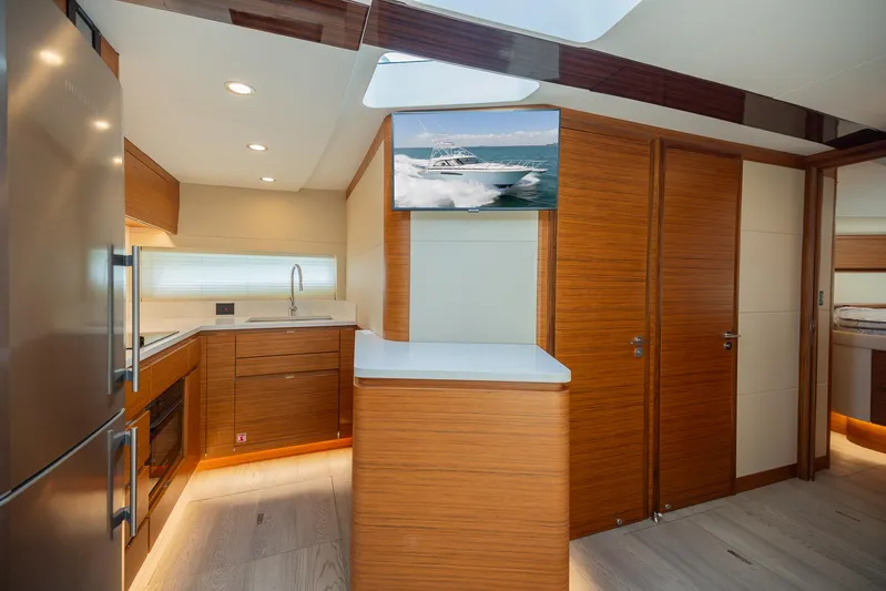  Yacht Photos Pics Modern kitchen interior of 2022 Bertram 50 yacht with wood finishes and stainless steel appliances.