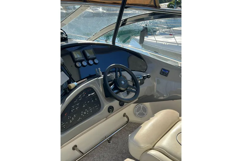  Yacht Photos Pics 2007 Cruisers Yachts 560 Express helm with steering wheel and control panel.