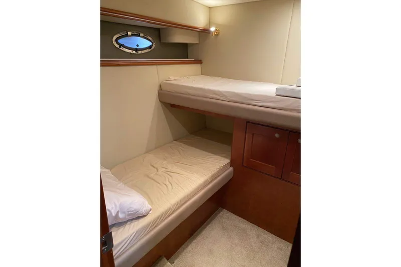  Yacht Photos Pics 2007 Cruisers Yachts 560 Express cabin with bunk beds and porthole window.