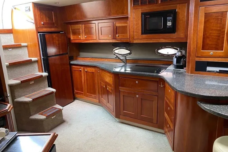  Yacht Photos Pics Luxurious 2007 Cruisers Yachts 560 Express kitchen with wood cabinetry and modern appliances.