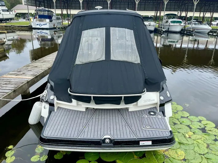  Yacht Photos Pics 2012 Monterey 328 SS boat docked, rear view with black cover, surrounded by water lilies.