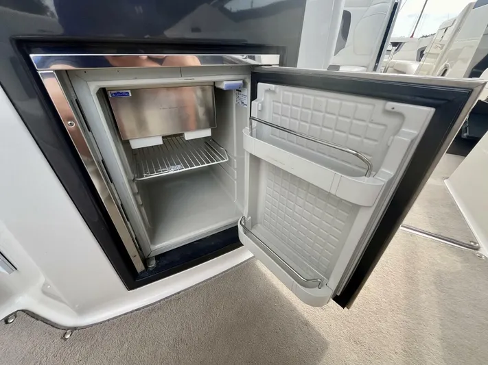  Yacht Photos Pics Open mini fridge on 2012 Monterey 328 SS boat, showing interior shelves and door storage.