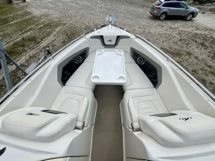  Yacht Photos Pics Bow seating area of a 2012 Monterey 328 SS boat with white upholstery and table.
