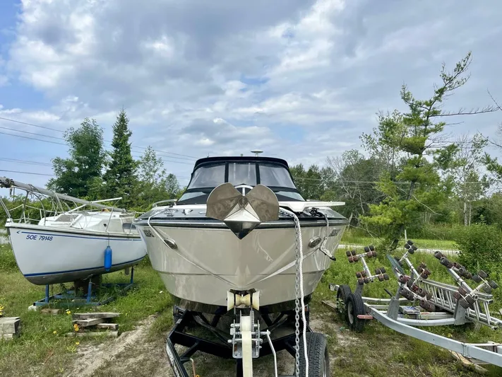  Yacht Photos Pics 2012 Monterey 328 SS boat on trailer, parked outdoors with trees and cloudy sky.