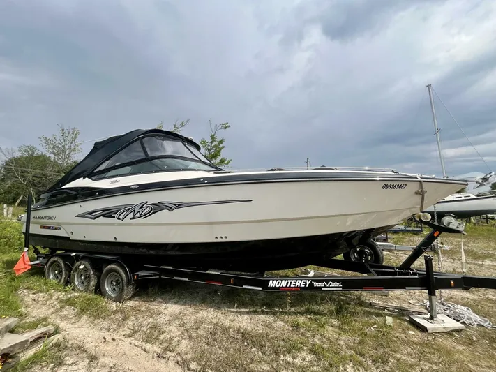  Yacht Photos Pics 2012 Monterey 328 SS boat on trailer, parked outdoors under cloudy sky.