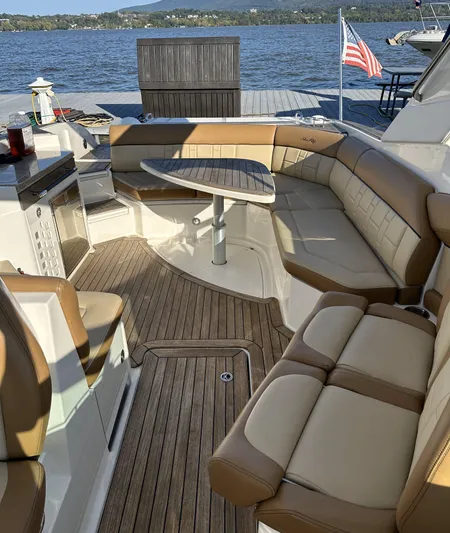  Yacht Photos Pics 2014 Sea Ray 350 SLX boat interior with tan seating and wooden deck, docked by a lake.