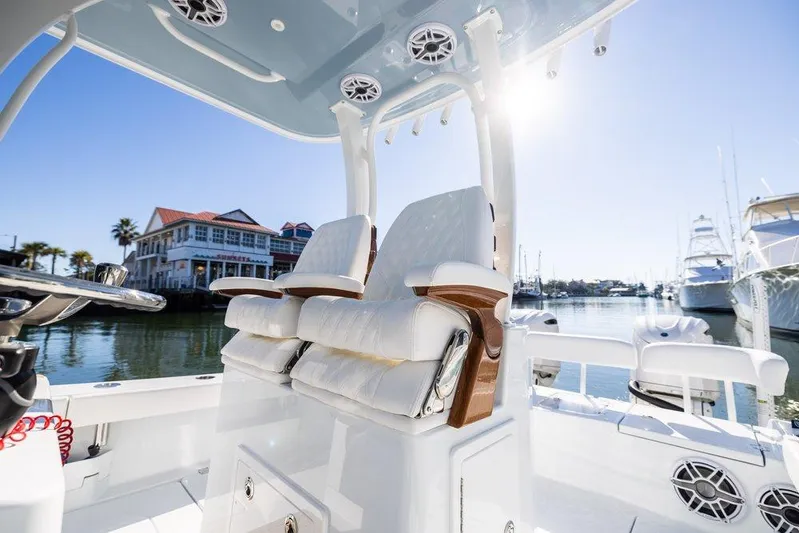  Yacht Photos Pics 2024 Freeman 28 boat interior with luxurious seating, docked near waterfront homes.