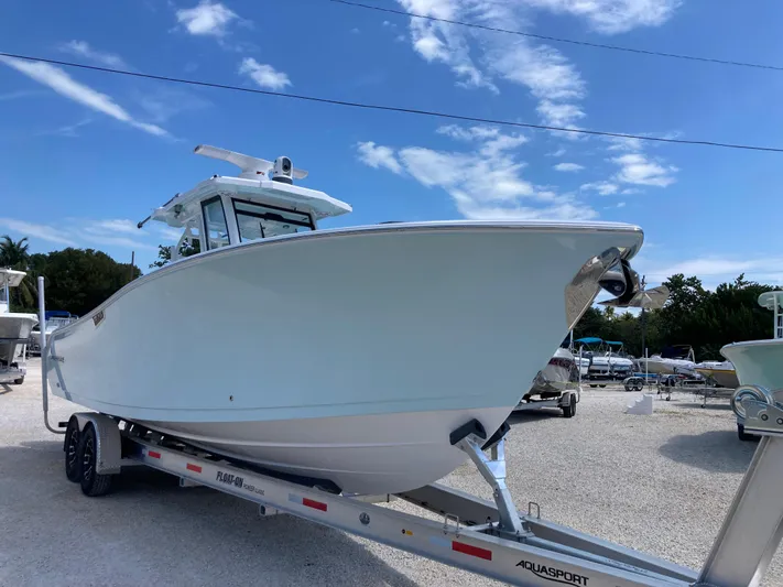  Yacht Photos Pics 2025 Aquasport 28AS boat on trailer under clear blue sky.