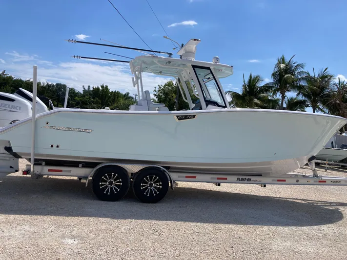  Yacht Photos Pics 2025 Aquasport 28AS boat on trailer, parked outdoors with palm trees in background.