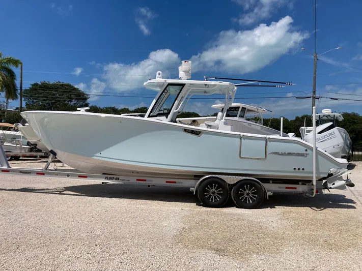  Yacht Photos Pics 2025 Aquasport 28AS boat on trailer under clear blue sky.