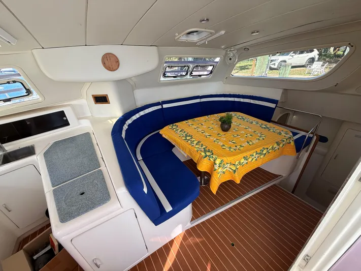 Tiki Yacht Photos Pics Interior of 2003 Leopard 38 yacht with blue seating and yellow tablecloth.