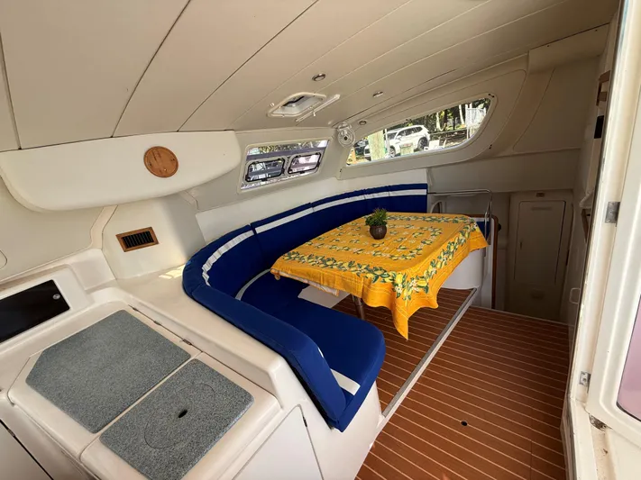 Tiki Yacht Photos Pics Interior of 2003 Leopard 38 yacht with blue seating and yellow tablecloth.