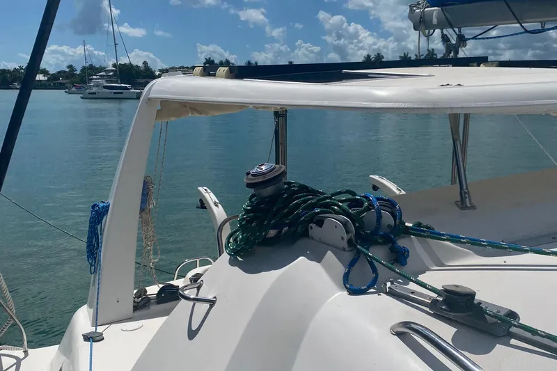 Tiki Yacht Photos Pics 2003 Leopard 38 catamaran deck with ropes, docked in a serene marina setting.