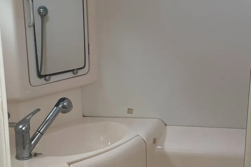 Tiki Yacht Photos Pics Compact bathroom in a 2003 Leopard 38 yacht, featuring a sink and mirror.