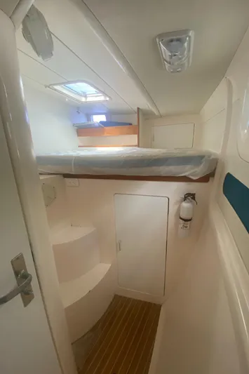 Tiki Yacht Photos Pics 2003 Leopard 38 interior cabin with bed, wooden flooring, and white walls.