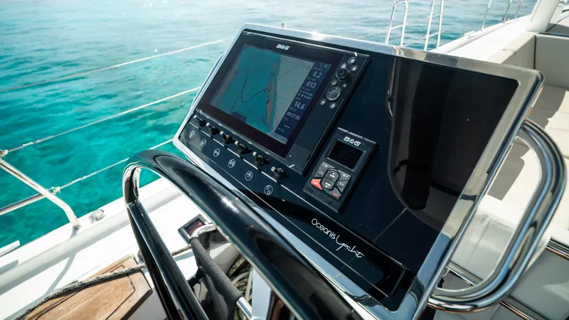Gwint Yacht Photos Pics Control panel of 2019 Beneteau Oceanis Yacht 62 with navigation display, overlooking clear blue water.