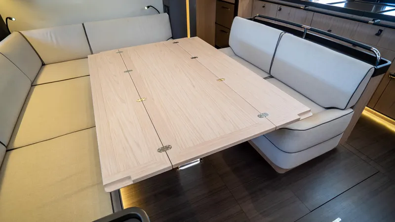 Gwint Yacht Photos Pics Luxurious interior of 2019 Beneteau Oceanis Yacht 62 with elegant seating and wooden table.