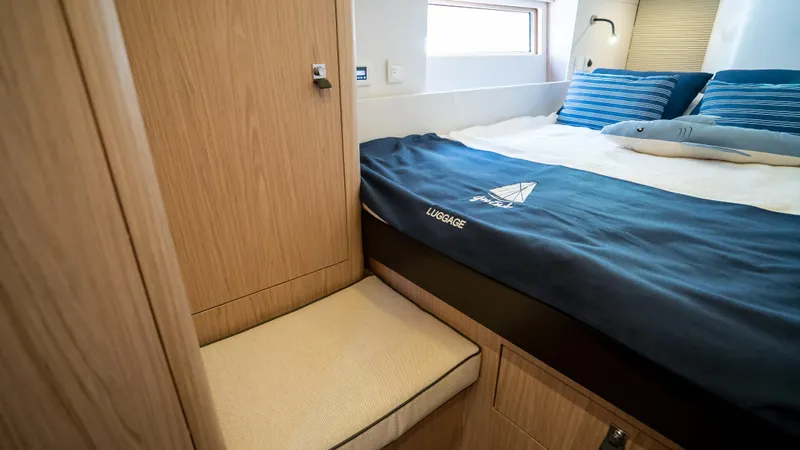 Gwint Yacht Photos Pics Luxurious cabin interior of 2019 Beneteau Oceanis Yacht 62 with cozy bedding and wooden finishes.