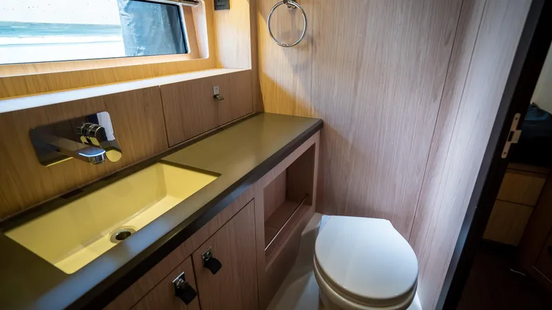 Gwint Yacht Photos Pics Luxurious bathroom in 2019 Beneteau Oceanis Yacht 62 with modern fixtures and wood finish.
