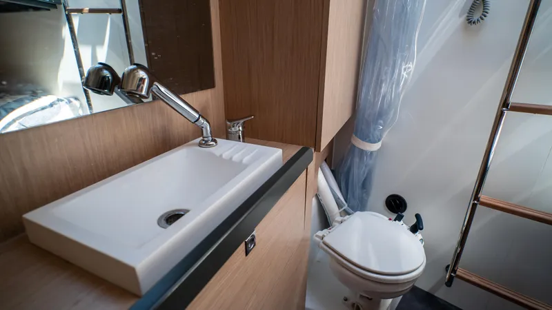 Gwint Yacht Photos Pics Modern bathroom in 2019 Beneteau Oceanis Yacht 62, featuring sleek sink and compact toilet.