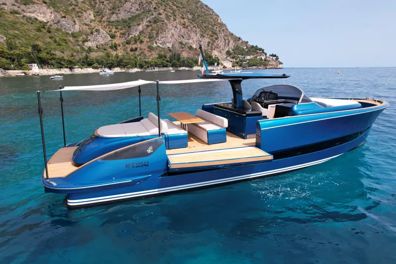  Yacht Photos Pics 2021 Solaris Power 48 OPEN yacht on clear blue water near rocky coastline.