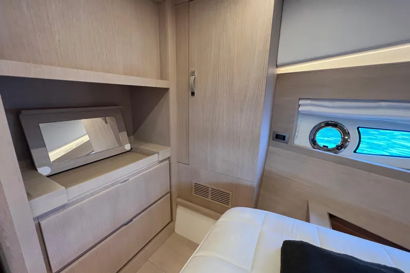  Yacht Photos Pics Luxurious interior of 2021 Solaris Power 48 OPEN yacht with elegant wood finish and porthole view.