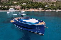 2021 Solaris Power 48 OPEN yacht on clear blue water near a scenic coastline.