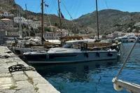 2024 Nimbus T11 X-Edition yacht docked in a scenic harbor with mountainous backdrop.