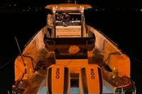 2024 Nimbus T11 X-Edition boat illuminated at night with underwater lights.