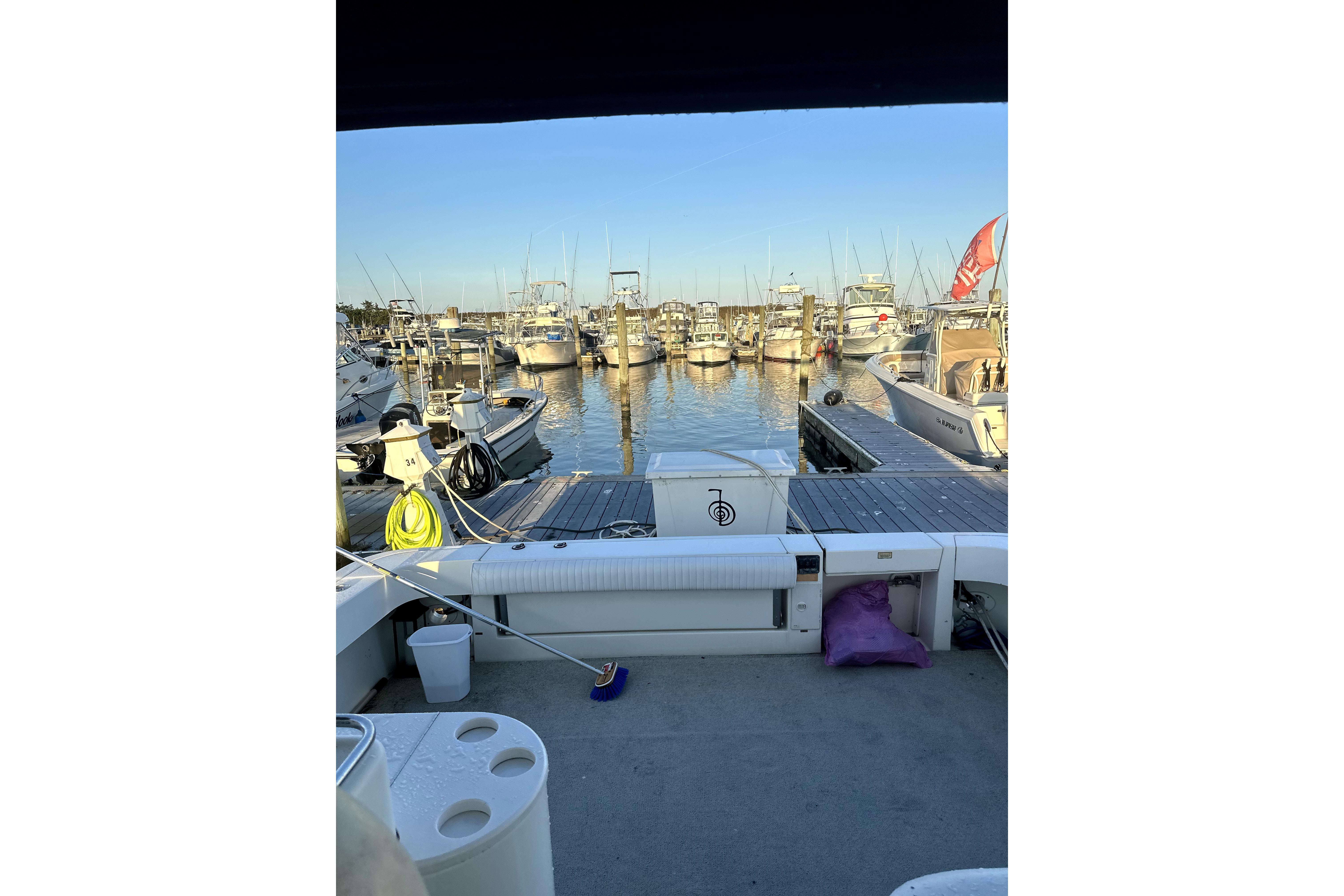 1998 Sea Ray 340 Amberjack at marina, surrounded by boats and clear blue sky.