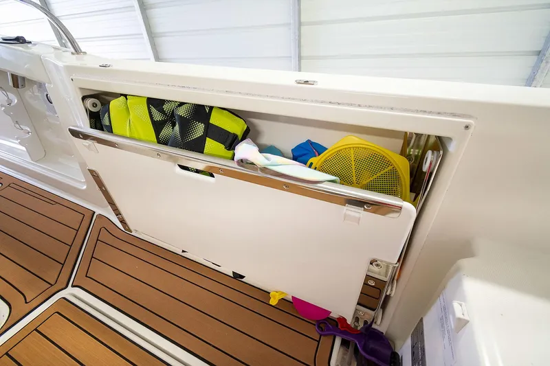  Yacht Photos Pics 2020 Jeanneau Leader 9.0 CC storage compartment with life jackets and accessories on teak deck.