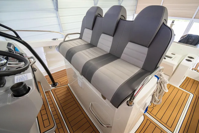 Yacht Photos Pics 2020 Jeanneau Leader 9.0 CC boat interior with three cushioned seats and wooden flooring.