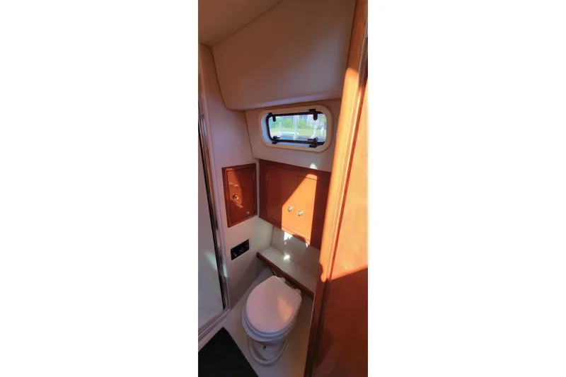  Yacht Photos Pics 2001 Zeta 32 Power Cat bathroom interior with wooden cabinets and a small window.