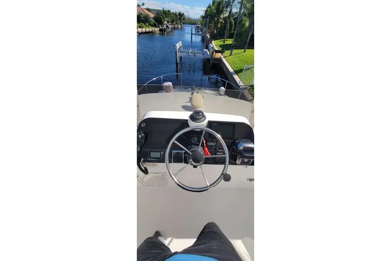  Yacht Photos Pics Helm view of 2001 Zeta 32 Power Cat on a sunny canal.