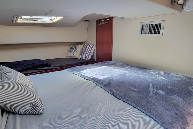  Yacht Photos Pics Cozy cabin interior of 2001 Zeta 32 Power Cat with comfortable bedding and nautical decor.