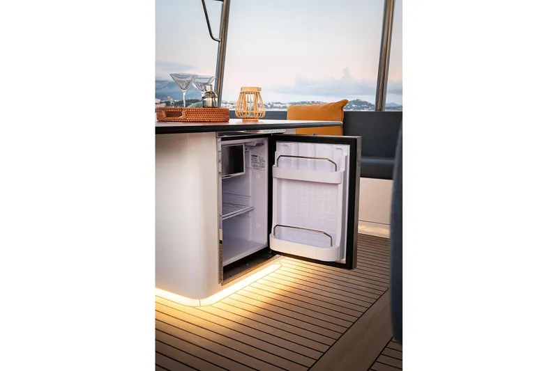 Lumiere Yacht Photos Pics Open mini fridge on Bali 5.2 yacht, 2026 model, with elegant interior and scenic view.