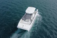 2022 Aquila Molokai 28 boat cruising on open water, aerial view.