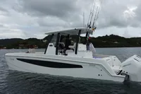 2022 Aquila Molokai 28 boat on water, equipped for fishing, with scenic background.