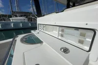 Aquila Molokai 28 (2022) boat storage compartment with tackle boxes, docked at marina.