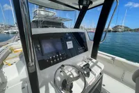 Cockpit view of 2022 Aquila Molokai 28 boat with steering wheel and control panel.