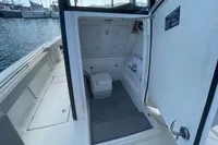 Aquila Molokai 28 boat interior with compact bathroom, docked at marina, 2022 model.