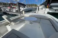 Aquila Molokai 28, 2022 model, docked at marina with seating and table.