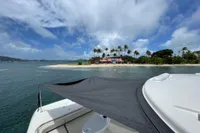 Aquila Molokai 28 (2022) yacht near tropical island with palm trees and blue sky.